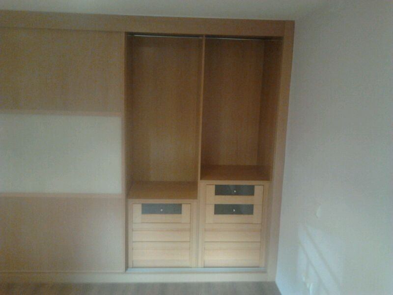 Armario de madera clara con puertas correderas y cajonera, montado por MECAR